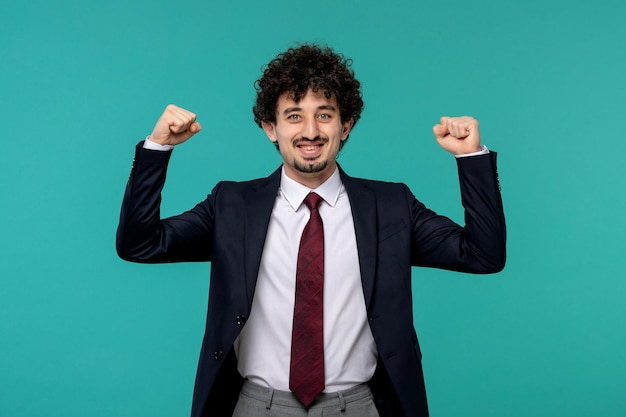 Free photo business man curly cute handsome guy in black suit excited holding fists