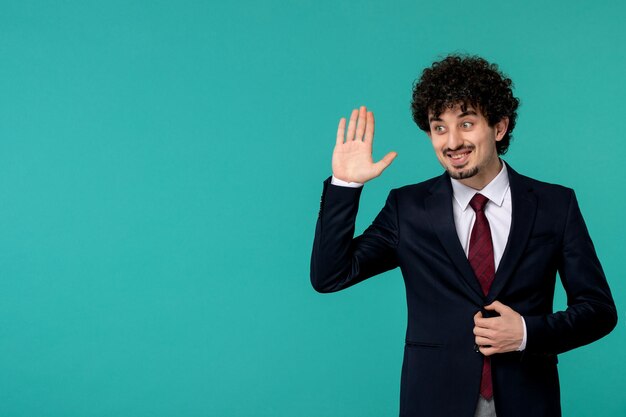 Business man curly cute handsome guy in black suit saying hi gesture sign and smiling