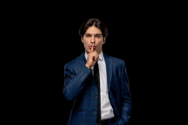 Free photo business man cute brunette man in dark blue outfit with the tie showing silence sign