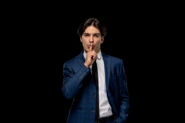 Business man cute brunette man in dark blue outfit with the tie showing silence sign