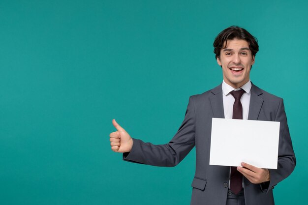 Business man cute handsome guy in grey office suit and tie smiling and holding a paper
