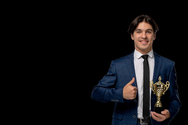 Free photo business man cute smiling guy in dark blue suit with the tie holding trophy