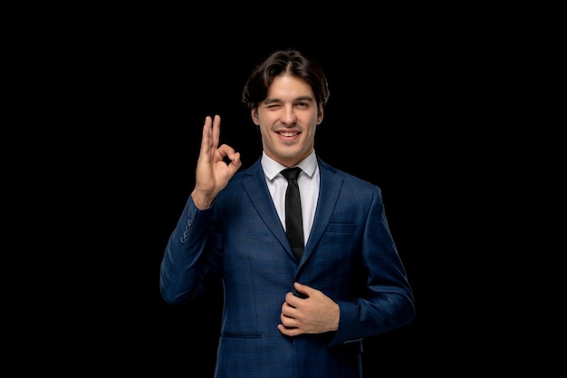 Business man cute smiling man in dark blue outfit winking and showing ok sign