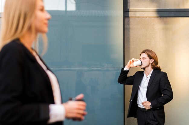 ビジネスの男性が外でコーヒーを飲む