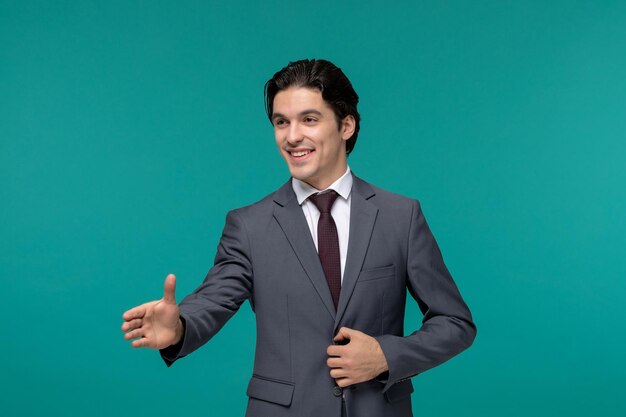 Деловой человек, красивый симпатичный брюнет в сером офисном костюме и галстуке, пожимающий руку