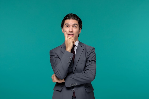 Business man handsome cute guy in grey office suit and tie looking up and thinking