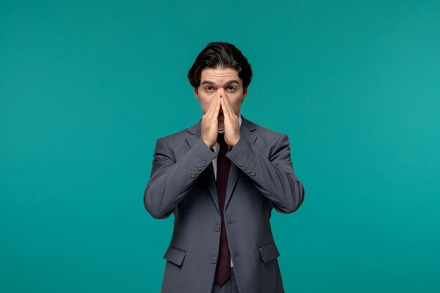 Business man handsome young brunette guy in grey office suit and tie covering nose