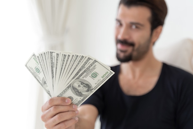 business man  holding money US dollar bills  in home office 