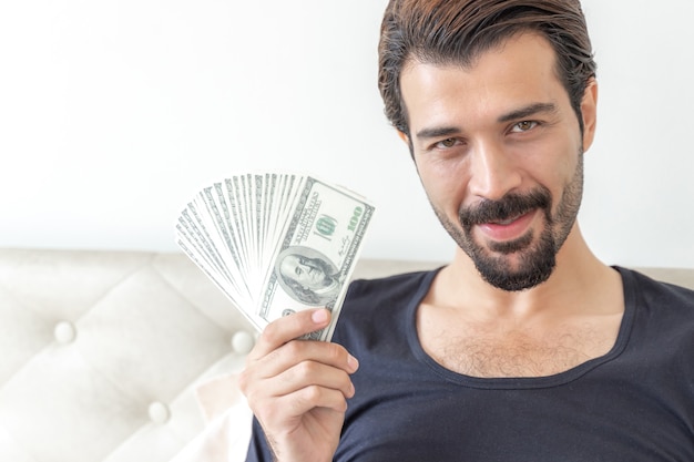 Free photo business man  holding money us dollar bills  in home office