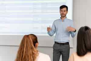 Free photo business man holding a presentation in the office for her colleagues