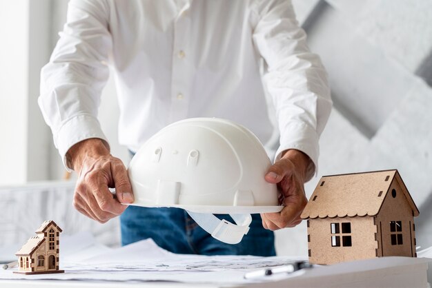 Business man holding a safety helmet 