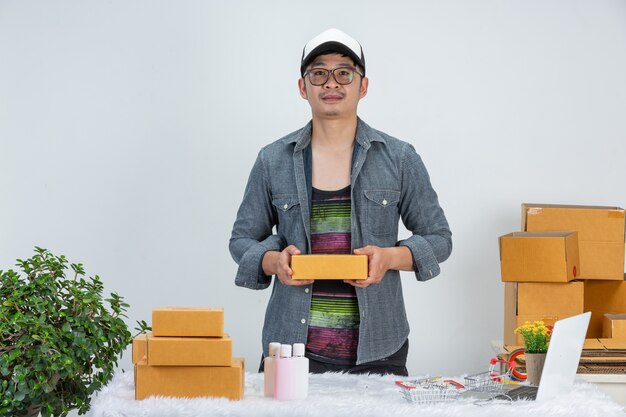 A business man is working online for customer at home office packaging on wall