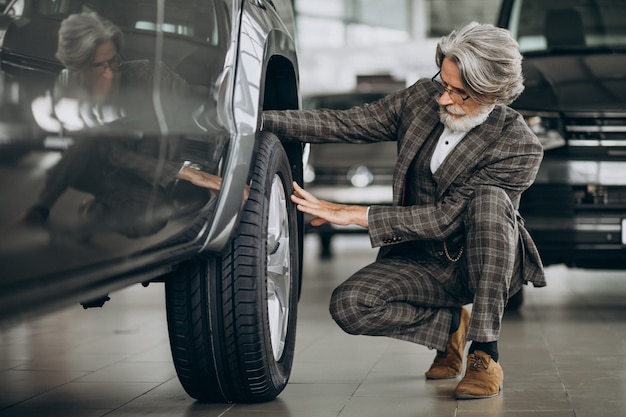 Foto gratuita uomo d'affari alla ricerca di un'auto in un salone di auto