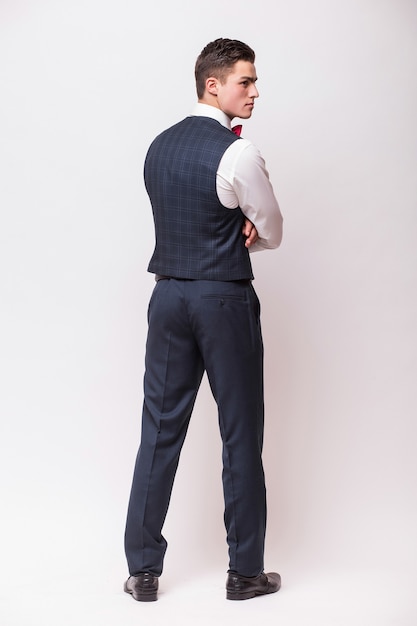 Business man posing backwards, isolated over white wall