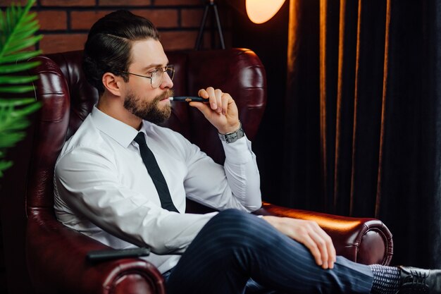 Business man resting and relaxing while sitting on sofa in luxury room