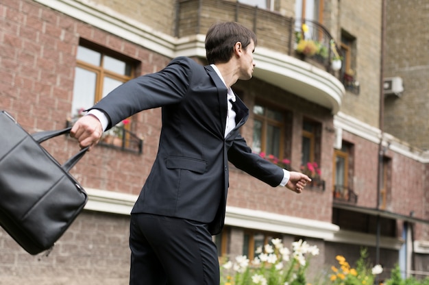 Free photo business man running with building in background