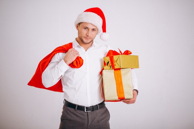 Business man in santa hat holding christmas present isolated