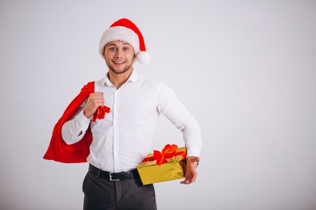 Business man in santa hat holding christmas present isolated