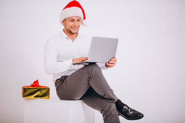 Деловой человек в шляпу Санта покупок в Интернете на Рождество