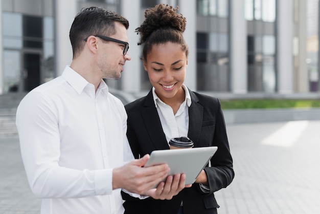 Free photo business man showing ipad to woman