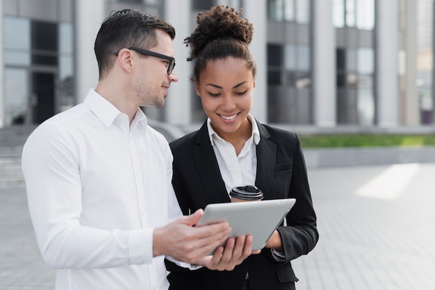 Business man showing ipad to woman