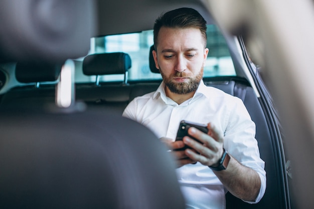 Business man sitting in a car using phone