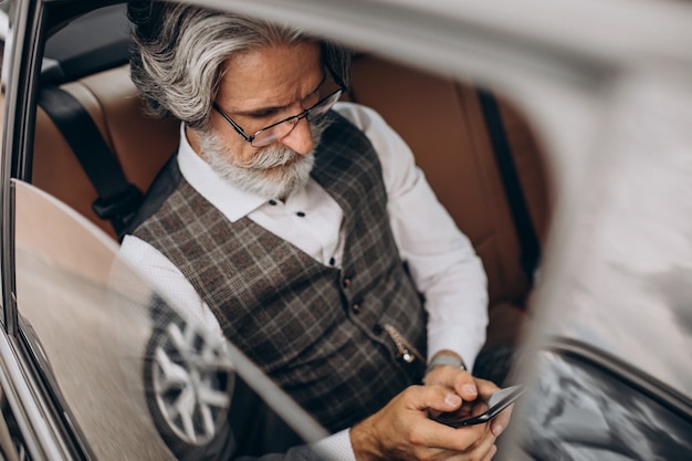 後ろに座って彼の車に座っているビジネスマン