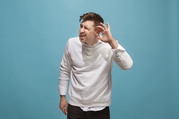 The business man standing and young man listening isolated on trendy blue studio.