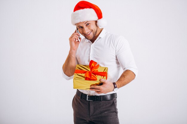 Деловой человек разговаривает по телефону в новогодней шапке на белом фоне