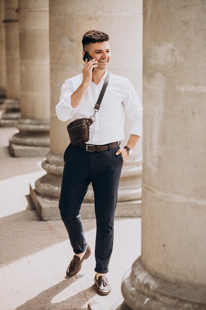 Business man using phone by the university