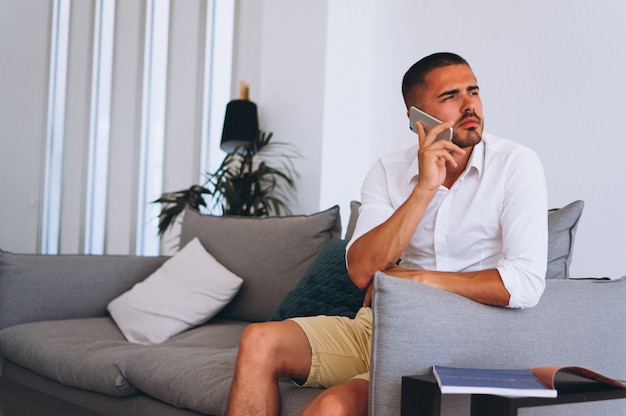 Uomo di affari con il telefono che si siede nel corridoio