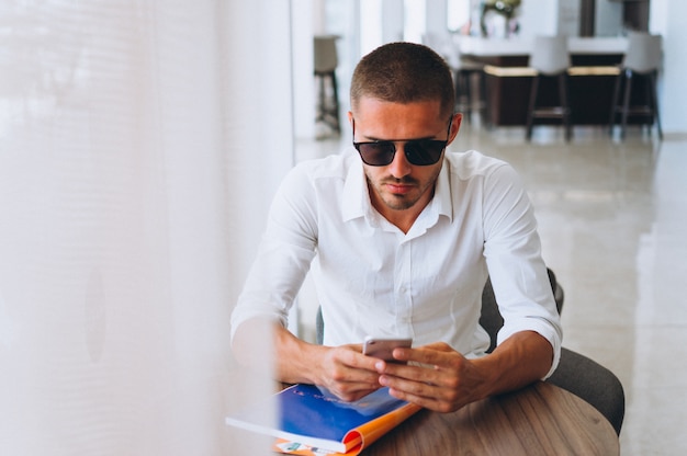 Business man with phone sitting at the table