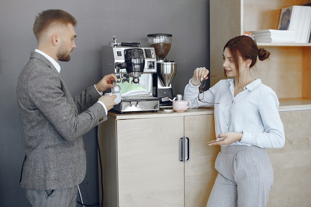 Business man and woman at the office. Coffee break in the hallway of the big corporation.