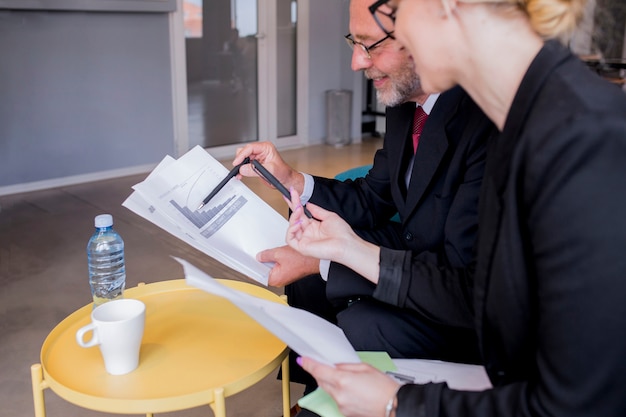 Free photo business man and woman sitting at desk talking about reports and finance