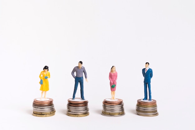 Business man and woman sitting on equal piles of coins