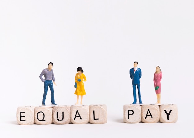 Business man and woman sitting on wooden cubes with equal pay written