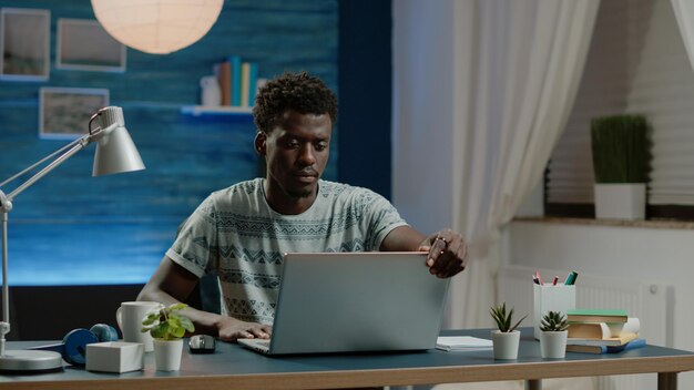 Деловой человек, работающий из дома с ноутбуком на столе. Предприниматель, использующий современное устройство для удаленной работы в Интернете с подключением к Интернету. Профессиональный работник делает проект с гаджетом