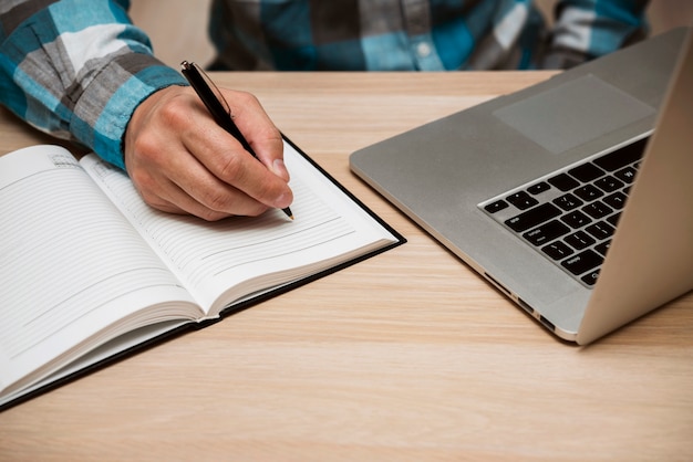 Business man writing in blank notebook