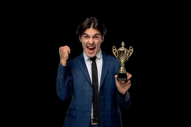 Free photo business man young excited handsome guy in dark blue suit with the tie holding trophy