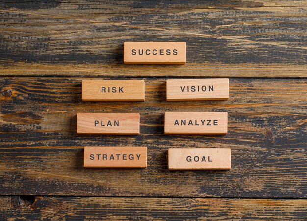 Business and marketing concept with wooden blocks on wooden table flat lay.