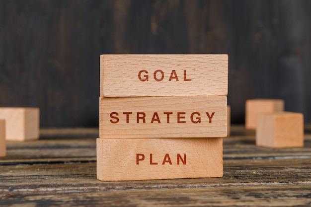 Business and marketing concept with wooden blocks on wooden table side view.