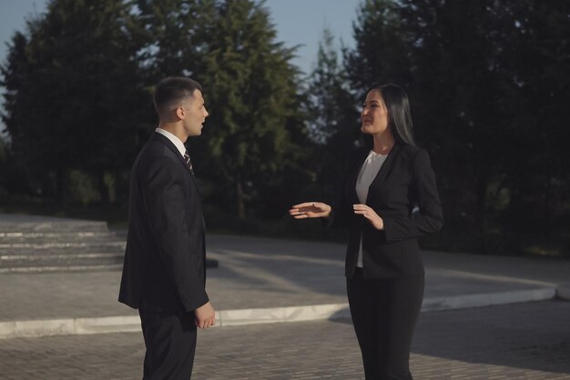 ビジネスミーティングの男性ときれいな女性が屋外で握手でお互いに挨拶します。