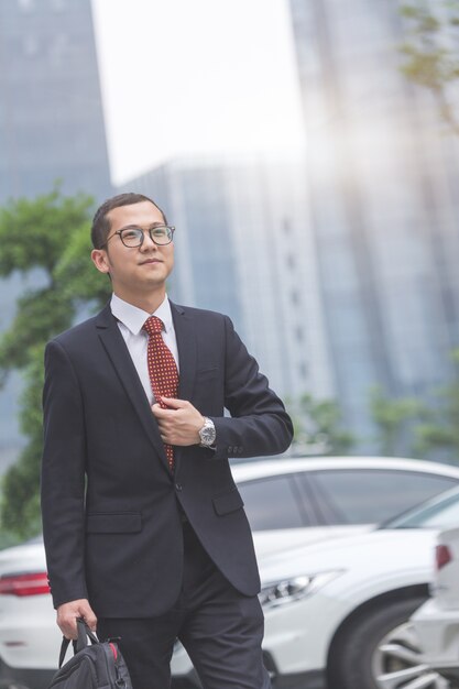 Business men carry laptops in the parking lot