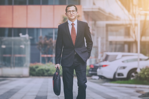 Business men carry laptops in the parking lot