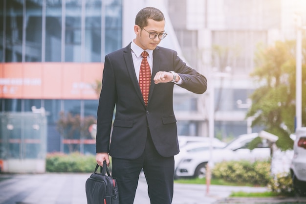 Business men carry laptops in the parking lot