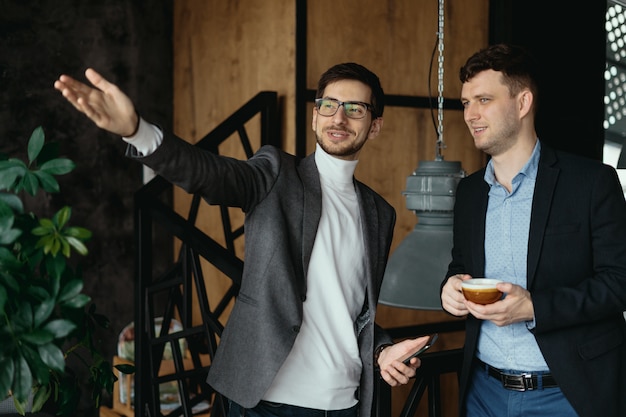 Business men conversation, pointing hand to the window