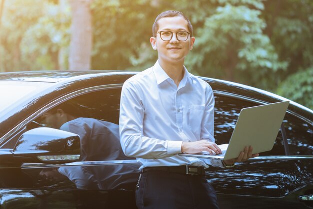 Business men use laptops alongside outdoor vehicles