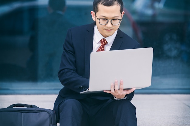 Business men use laptops at the entrance of an office building