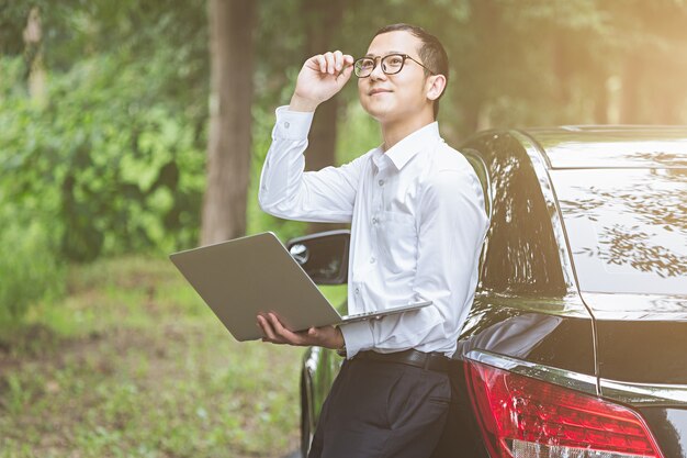 Business men work with laptops on the side of the car