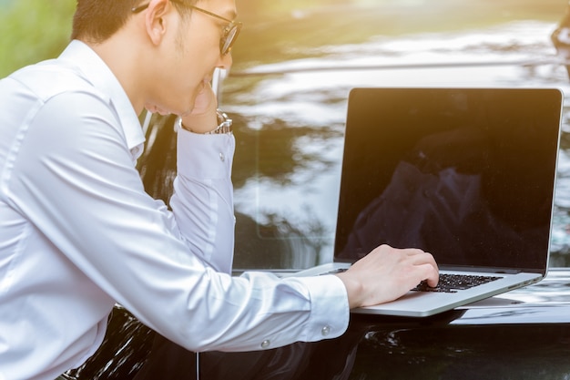 Free photo business men work with laptops on the side of the car